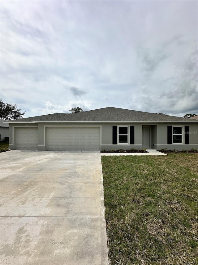 ranch-style house featuring a garage, a front yard, concrete driveway, and stucco siding