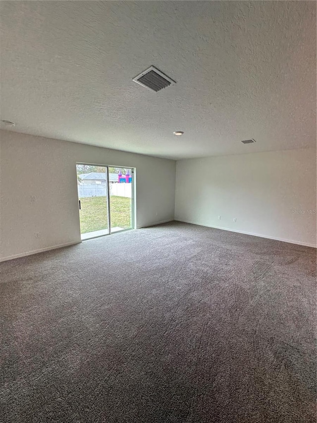 carpeted empty room with a textured ceiling, visible vents, and baseboards