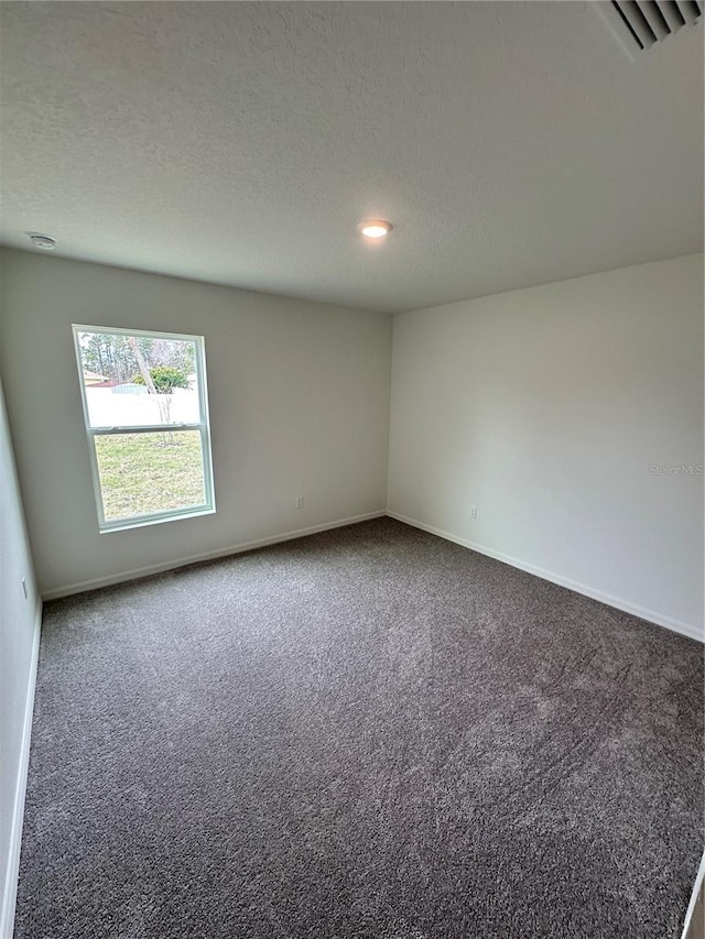 empty room featuring visible vents, a textured ceiling, baseboards, and carpet flooring