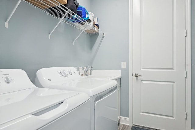 laundry room featuring washing machine and dryer, cabinet space, and a sink