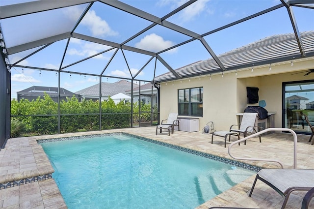 outdoor pool featuring ceiling fan, a patio area, and a lanai