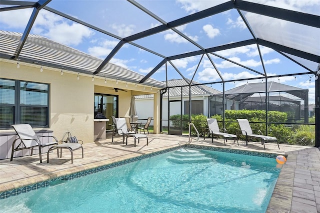 pool with a lanai, a patio, and ceiling fan