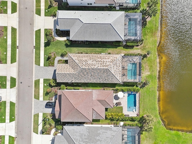 drone / aerial view of a nearby body of water and a pool
