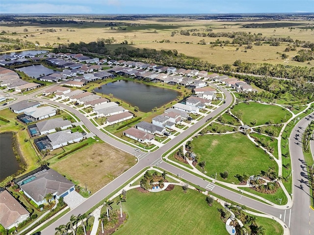 aerial view of property and surrounding area featuring a large body of water and nearby suburban area