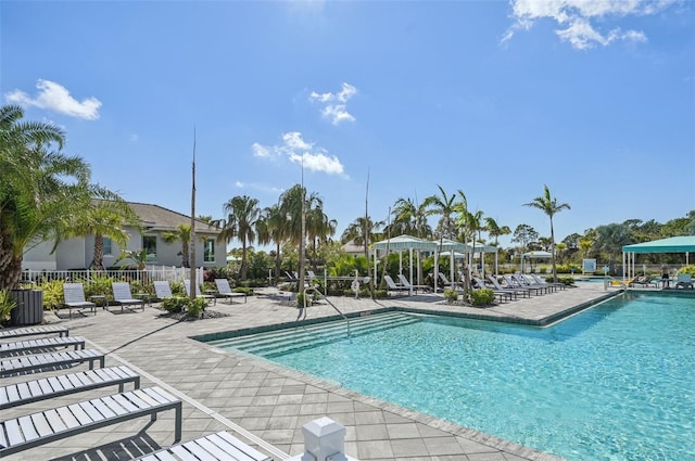 community pool featuring a patio area, fence, and central AC