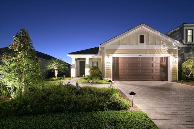 view of front of house featuring an attached garage, decorative driveway, and board and batten siding