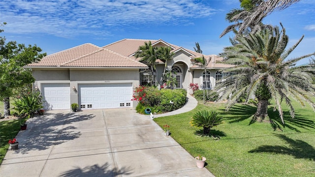 view of front of house featuring an attached garage, a tiled roof, driveway, stucco siding, and a front lawn