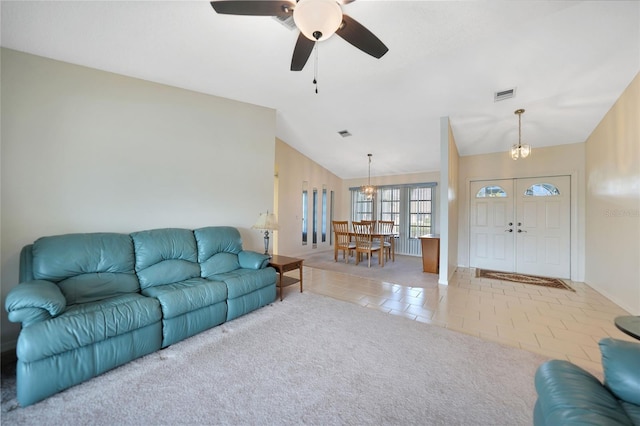 living room featuring light carpet, light tile patterned floors, visible vents, lofted ceiling, and ceiling fan