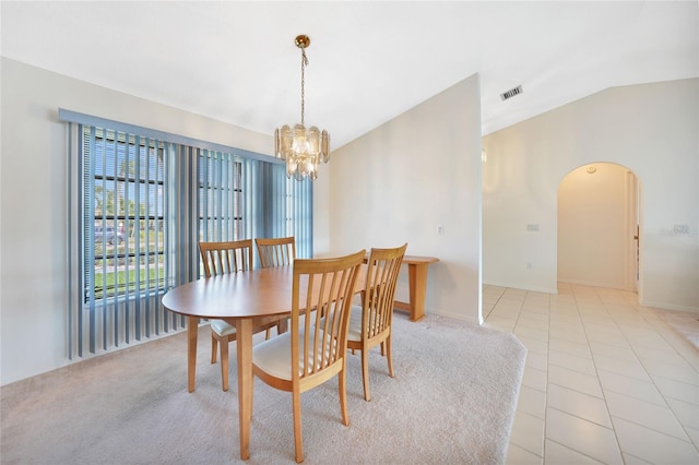 dining room featuring visible vents, arched walkways, lofted ceiling, a chandelier, and light tile patterned flooring