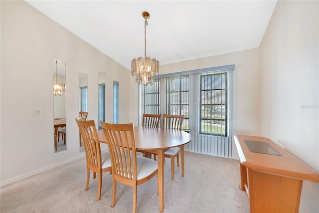 dining room with a chandelier, vaulted ceiling, and light colored carpet