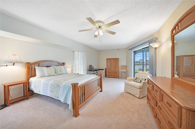 bedroom with a ceiling fan, light colored carpet, and a textured ceiling