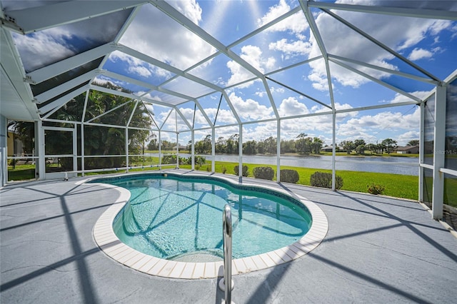 pool with a water view, glass enclosure, and a patio