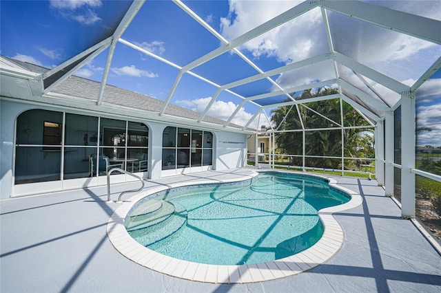 outdoor pool featuring glass enclosure and a patio