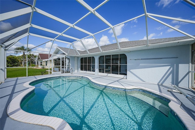 pool with glass enclosure and a patio area