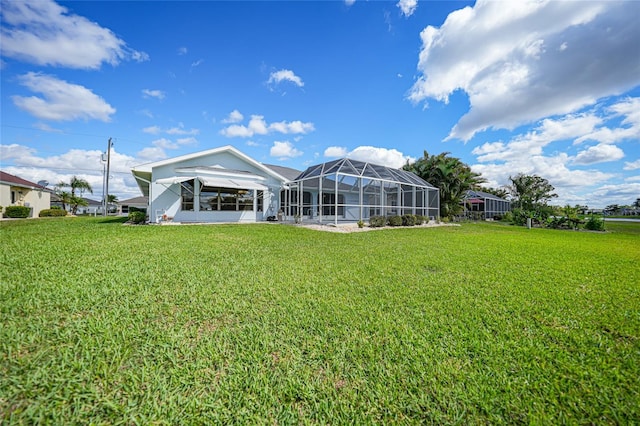 rear view of house with a lawn and a lanai