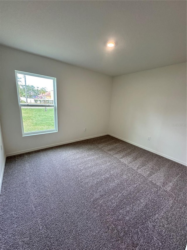 carpeted empty room with baseboards