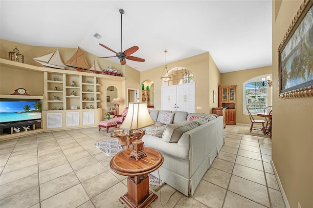 living area with arched walkways, ceiling fan, light tile patterned floors, lofted ceiling, and visible vents