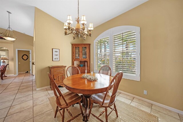 dining room featuring arched walkways, vaulted ceiling, baseboards, and light tile patterned floors