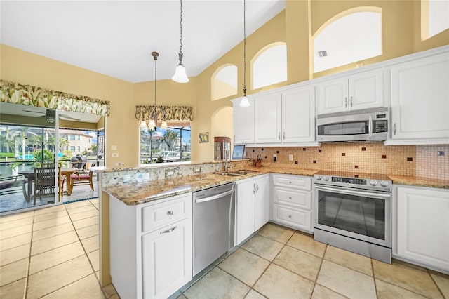 kitchen featuring high vaulted ceiling, stainless steel appliances, a peninsula, white cabinets, and decorative backsplash