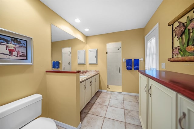 full bath featuring baseboards, tiled shower, toilet, vanity, and recessed lighting