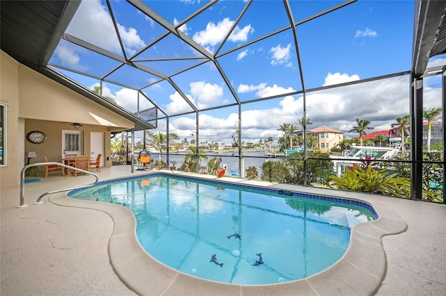 outdoor pool with ceiling fan, a patio, and glass enclosure