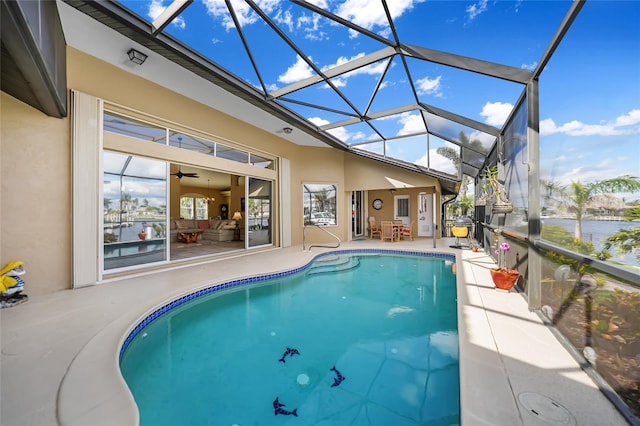 pool with a patio, a water view, and a lanai