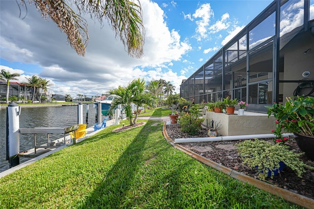 view of yard featuring a dock, a water view, and a lanai