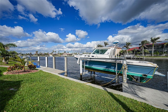 dock area with a yard, a water view, and boat lift