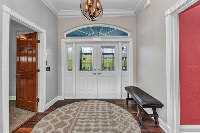 entryway featuring an inviting chandelier, dark wood-style flooring, ornamental molding, and baseboards