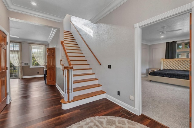 stairway with baseboards, visible vents, crown molding, and wood finished floors