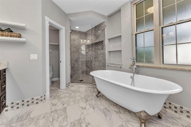 full bathroom featuring a shower stall, baseboards, marble finish floor, toilet, and a freestanding tub
