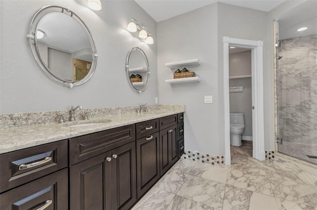 full bath featuring a shower stall, marble finish floor, double vanity, toilet, and a sink