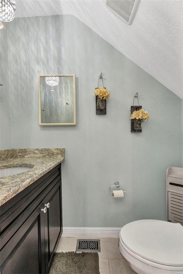 bathroom with lofted ceiling, visible vents, tile patterned floors, and vanity