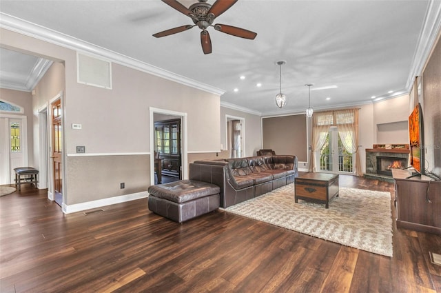living area featuring dark wood finished floors, visible vents, a lit fireplace, and a ceiling fan