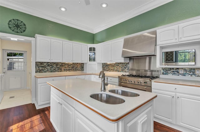 kitchen with ornamental molding, wall chimney exhaust hood, a sink, stainless steel range, and dark wood-style floors