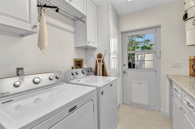 laundry room with light tile patterned flooring, cabinet space, baseboards, and washer and dryer