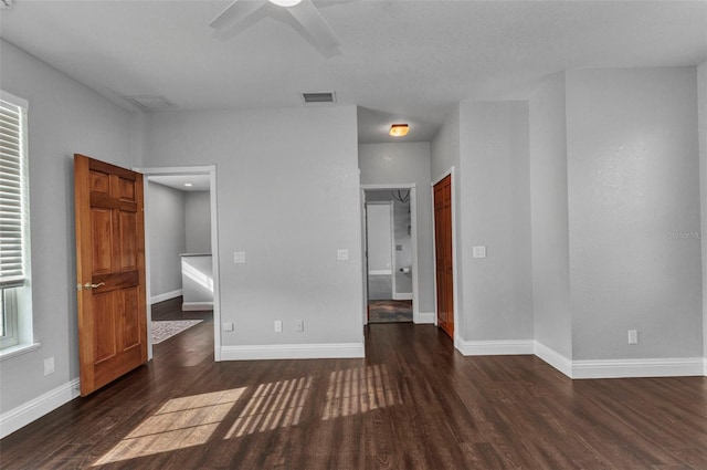 unfurnished room featuring baseboards, visible vents, ceiling fan, and wood finished floors