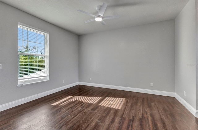 unfurnished room featuring baseboards, dark wood-style flooring, and a ceiling fan