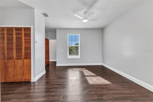 unfurnished bedroom featuring a ceiling fan, dark wood-style floors, baseboards, and visible vents