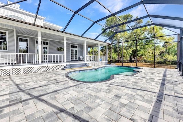 outdoor pool with glass enclosure, a patio area, and french doors