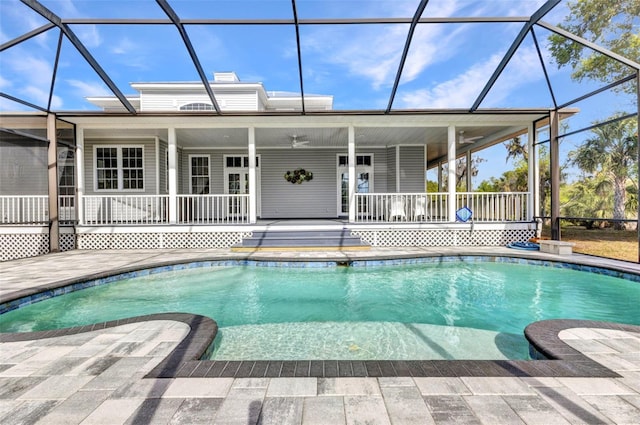 pool featuring glass enclosure, a ceiling fan, and a patio area