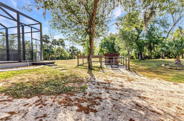 view of yard with glass enclosure and an outdoor structure