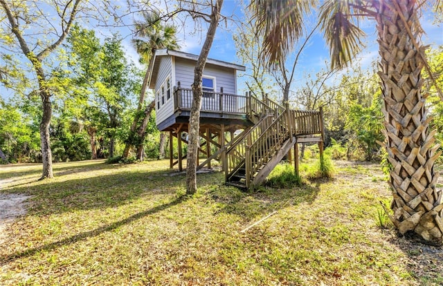 exterior space with a wooden deck, stairway, and a yard