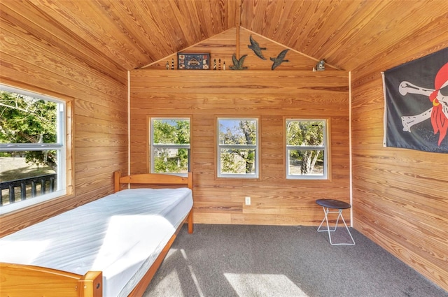 bedroom featuring multiple windows, lofted ceiling, wooden walls, and wood ceiling
