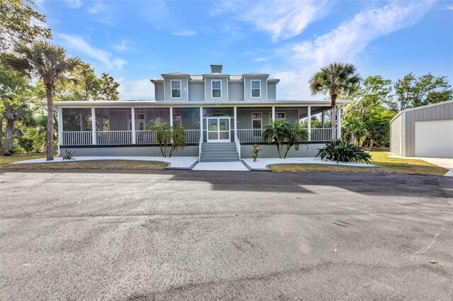 5601 Taylor Rd, Punta Gorda, FL 33950 - farmhouse-style home with a sunroom and an outbuilding