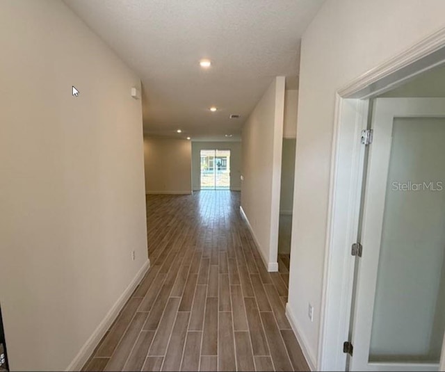 corridor with recessed lighting, dark wood-style flooring, and baseboards