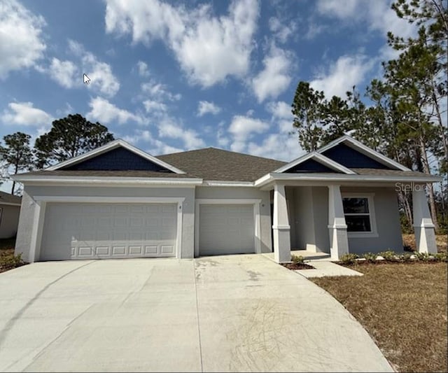 view of front of property with concrete driveway, an attached garage, and stucco siding