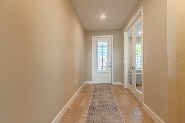 doorway with light wood-style floors and baseboards