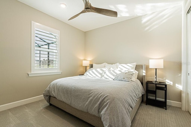 bedroom featuring light carpet, ceiling fan, and baseboards