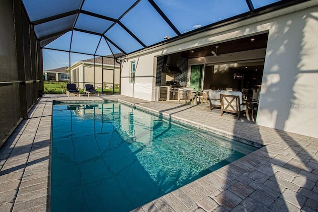 outdoor pool featuring a lanai, a patio area, ceiling fan, and exterior kitchen